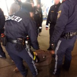 Aktivist am Boden gefesselt, von Polizei umringt