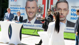 Ein Aktivist mit Foto unterbricht Wahlveranstaltung der FPÖ